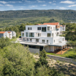 Modern home amidst lush hillside greenery
